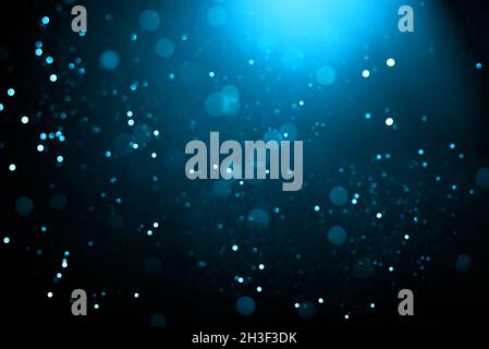Abstrakter Hintergrund mit glühenden türkisfarbenen Partikeln. Stockfoto