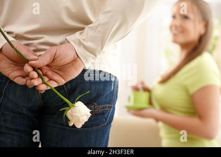 Mann überraschend Frau mit Blume Stockfoto