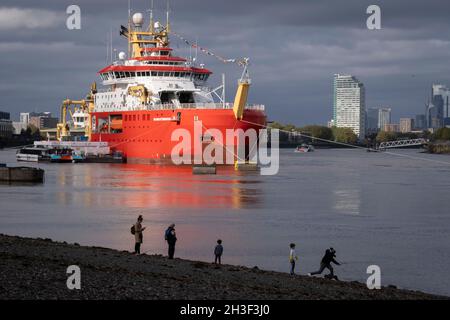 Die Londoner stehen am Ufer der Themse und bewundern das neue Polarforschungsschiff der British Antarctic Survey, das RRS Sir David Attenborough, das auf der Themse am Prime Meridian, Greenwich, vor Anker liegt, während seines kurzen Aufenthalts, der der Öffentlichkeit gezeigt wird, während der COP26-Klimakonferenz in Glasgow, Am 28. Oktober 2021 in London, England. Der £200m Attenborough ist ein Eisbrecher der Polar Klasse 4 mit modernster Forschungsausrüstung, einem Hubschrauberlandeplatz, Kränen, Laboren an Bord und anderen Geräten zur Meeresuntersuchung und Probenahme. Stockfoto