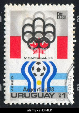 URUGUAY - UM 1975: Briefmarke gedruckt von Uruguay, zeigt das olympische Wappen von Montreal und Argentinien '78, um 1975 Stockfoto