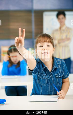 Schulmädchen heben Hand Stockfoto