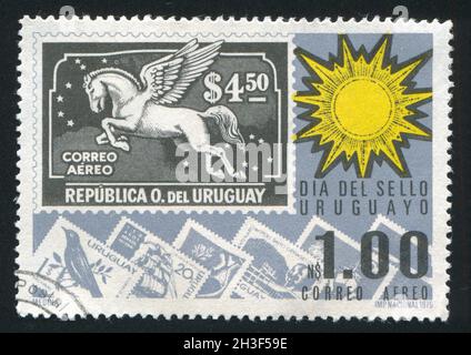 URUGUAY - UM 1975: Briefmarke gedruckt von Uruguay, zeigt Sonne und Briefmarken, um 1975 Stockfoto