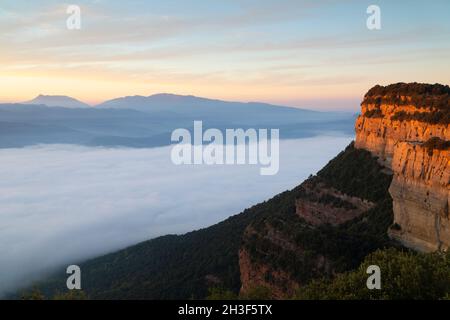 Thermische Inversion bei einem Herbstaufgang an den Tavertet Cliffs (Cingles de Tavertet), mit dem Berg Montseny im Hintergrund. Tavertet, Osona, Barcelona Stockfoto