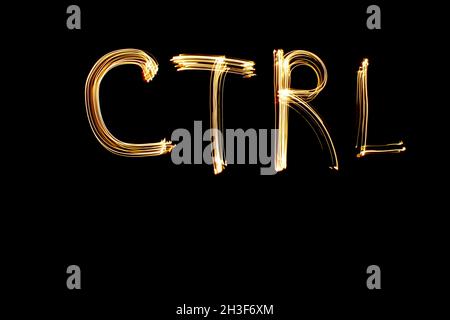 Das Wort „CTRL“, das in leichter Maltechnik vor schwarzem Hintergrund geschrieben wurde. Langzeitbelichtung. Stockfoto
