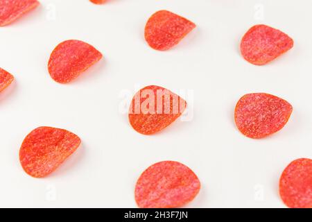 Tortilla-Chips-Muster auf rotem Hintergrund. Wiederholungskonzept. Draufsicht Stockfoto