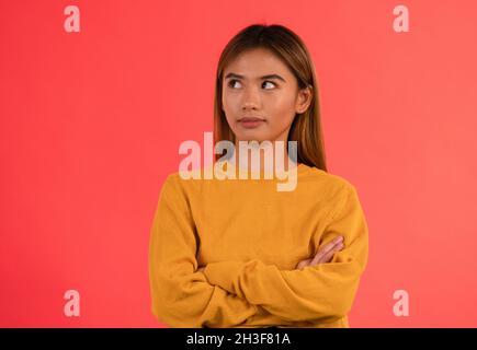 Junge attraktive mürrische asiatische Mädchen Rollen ihre Augen mit den Armen gekreuzt Stockfoto