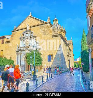 GRANADA, SPANIEN - 27. SEPTEMBER 2019: Die prächtige Fassade der mittelalterlichen Basilika St. Justus und Pastor, geschmückt mit einem Portal aus Reliefstein, gekrönt mit sc Stockfoto