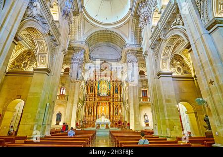 GRANADA, SPANIEN - 27. SEPTEMBER 2019: Innenraum des mittelalterlichen Heiligtums unserer Lieben Frau von der ewigen Hilfe mit riesigen Steinmauern, schönen hölzernen Altarbild und Stockfoto