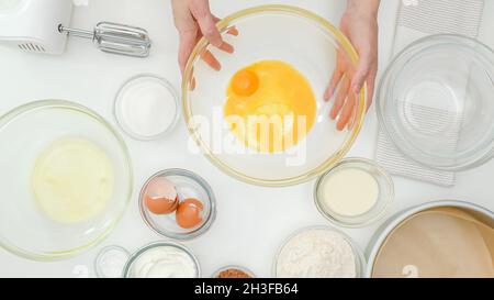 Eigelb, Eiweiß, Mehl, Zucker und einige Zutaten für das Kuchenrezept aus nächster Nähe auf dem Küchentisch. Hausgemachte Schokoladenkuchen Schritt für Schritt Backproce Stockfoto