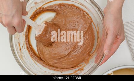 Schokoladenkuchen Rezept. Mischen Sie den Teig in einer Glasschüssel. Nahaufnahme Backvorgang, flach legen Stockfoto