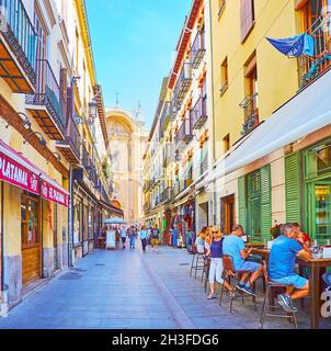 GRANADA, SPANIEN - 27. SEPTEMBER 2019: Die schmale Fußgängerzone Marques de Gerona Straße mit Outdoor-Bars, Restaurants und Portal der Kathedrale im Hintergrund, o Stockfoto