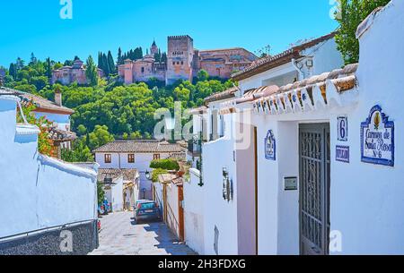 GRANADA, SPANIEN - 27. SEPTEMBER 2019: Das hügelige Albaicin-Viertel ist der perfekte Ort, um die Alhambra zu beobachten, die hinter den alten Häusern zu sehen ist Stockfoto