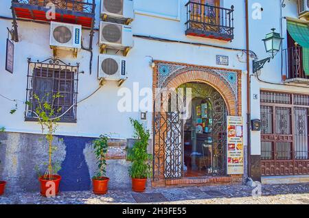 GRANADA, SPANIEN - 27. SEPTEMBER 2019: Der Eingang zum Restaurant im Mudejar-Stil mit einem Bogen, der mit Ziegeln umrahmt und mit feinen islamischen Mustern bebaut ist Stockfoto