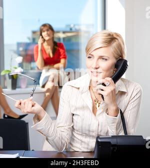 Geschäftsfrau, die auf dem Festnetztelefon spricht Stockfoto