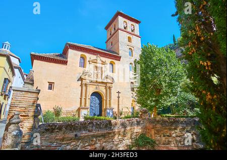 Die mittelalterliche Steinfassade der Kirche San Pedro und Pablo mit geschnitzten Steindekorationen und einem hohen Glockenturm befindet sich in der Carrera del Darro Straße von Alba Stockfoto