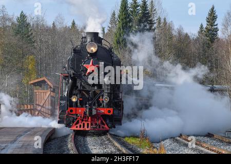 RUSKEALA, RUSSLAND - 07. OKTOBER 2021: Der touristische Retrozug 'Ruskeala Express' kommt an einem sonnigen Oktoberfest auf dem Bahnhof des Ruskeala Mountain Park an Stockfoto