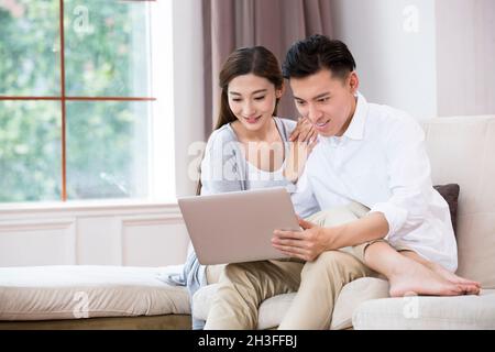 Junges Paar mit einem Laptopcomputer Stockfoto