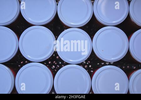 Unterseite der weißen Kappen in Kunststoffbox mit Löchern. Selbstgemachte Deckel aus Dosen. La Cienz, Spanien. Stockfoto