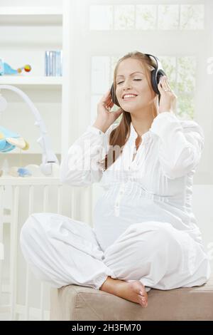 Schwangere Frau Musik hören Stockfoto