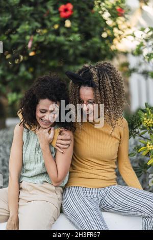 Vertikale Aufnahme von zwei spanischen kaukasischen Weibchen, die lächeln Stockfoto