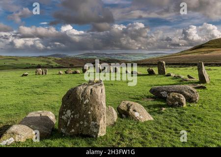 Teil des Steinkreises Swinside aka Sunkenkirk; helle Nachmittagssonne, blauer Himmel mit grauen und weißen Wolken, die der Form der Steine entsprechen. Stockfoto