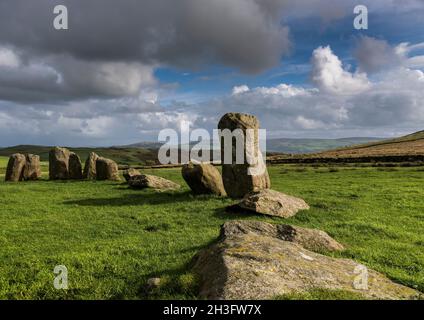 Teil des Steinkreises Swinside aka Sunkenkirk; helle Nachmittagssonne, blauer Himmel mit grauen und weißen Wolken, die der Form der Steine entsprechen; lange Schatten Stockfoto