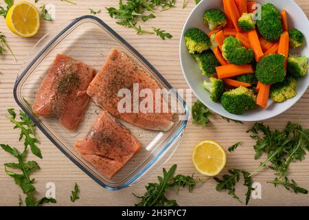 Scheiben von rohem Lachs in einem zum Kochen bereiten Tablett und Gemüse - Draufsicht Stockfoto