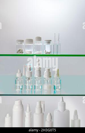 Regale mit pharmazeutischen Produkten. Medikamente in verschiedenen Formen der Freisetzung. Flaschen von Tabletten, Gläser von Pillen, Flaschen mit Lösungen von Suspensionen. Stockfoto