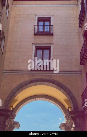 Foto einer typischen Straße der Plaza Mayor mit einem Bogenweg und Balkonen und alten Fenstern in Madrid, Spanien Stockfoto