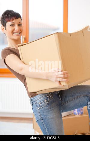 Junge Frau hebt Karton Stockfoto