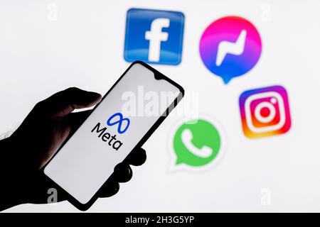 Facebook ändert seinen Namen in Meta. Smartphone mit Meta-Logo auf dem Hintergrund auf Logos von Produkten von facebook Metaverse. Stockfoto