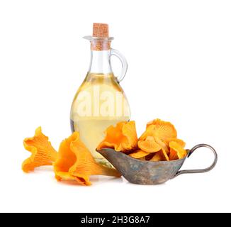 Olivenöl mit gelben Pfifferlingen Pilze in silbernem Sauceboat isoliert auf weißem Hintergrund Stockfoto