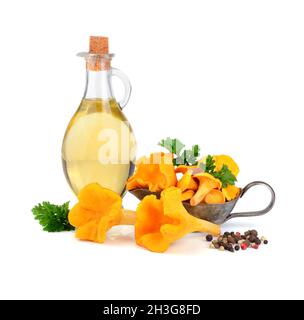 Olivenöl mit gelben Pfifferlingen Pilze in silbernem Sauceboat isoliert auf weißem Hintergrund Stockfoto