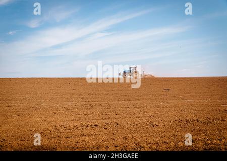 Bauer Pflügefeld mit einem Traktor im April 2021 Stockfoto