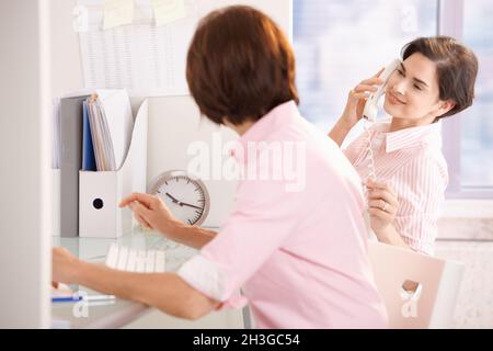 Kollegen sitzen zusammen am Schreibtisch Stockfoto
