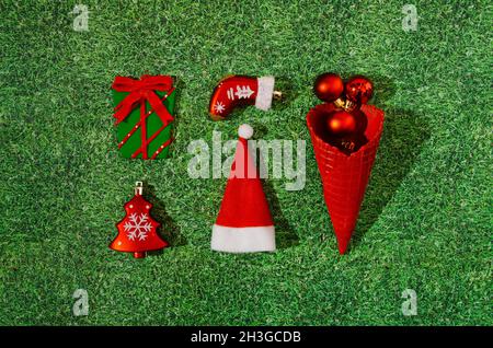 Eine helle Infografik oder ein Muster aus Weihnachtsdekoration: Ein Weihnachtsbaum, ein eingewickeltes Geschenk, ein Stiefel, ein Weihnachtsmütze und ein roter Eiskegel mit Rot Stockfoto