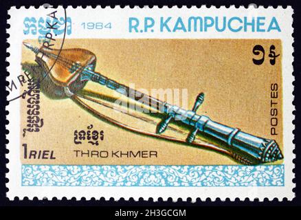 KAMBODSCHA - UM 1984: Eine in Kambodscha gedruckte Briefmarke zeigt durch khmer, Musikinstrument, um 1984 Stockfoto