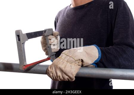 Mann schneidet Eisenrohr mit Handsäge, isoliert auf weißem Hintergrund. Unbekannte Person, die Stahlrohr sägt. Verwenden einer Bügelsäge. Stockfoto