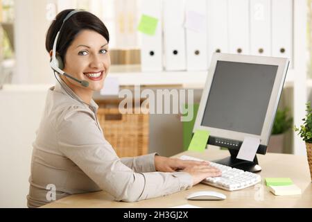 Assistent, der am Headset spricht Stockfoto