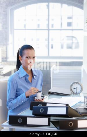 Geschäftsfrau mit Kaffee an der Rezeption Stockfoto