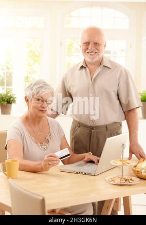 Ältere Paare, die im Internet einkaufen Stockfoto