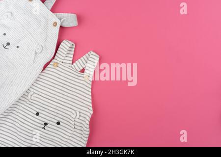Baby Kleidung auf rosa Hintergrund Draufsicht Stockfoto