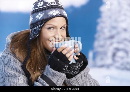 Attraktive Skifahrer trinken Heißgetränk lächelnd Stockfoto