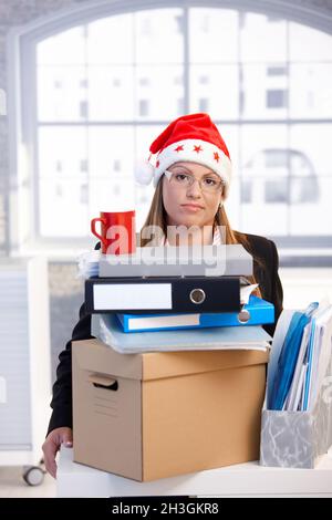 Junge Frau in santa hat im Büro niedergeschlagen Stockfoto