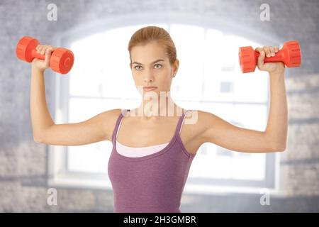 Junge Frau, die das Training mit Hanteln Stockfoto