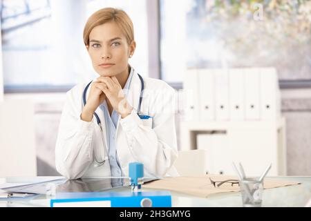 Junge Ärztin am Schreibtisch Stockfoto