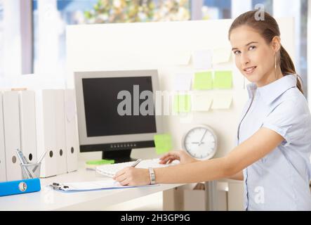 Junge Büroangestellte Frau am Schreibtisch Stockfoto