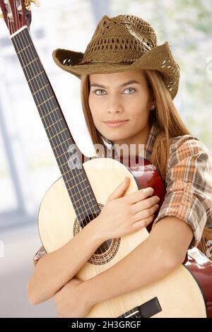 Gitarrist Mädchen umarmt Gitarre lächelnd Stockfoto