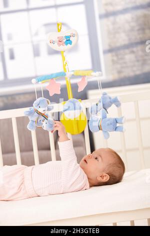 Baby spielt mit Bettmobil Stockfoto