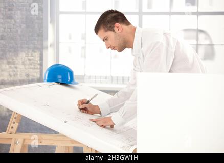 Junger Ingenieur, der mit Arbeit beschäftigt ist Stockfoto